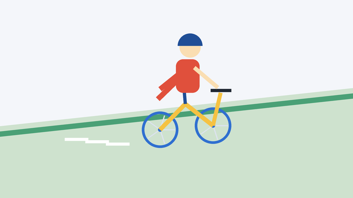 Una pendiente suave con hierba y un niño deslizándose, con los pies en alto, en una bici sin pedales